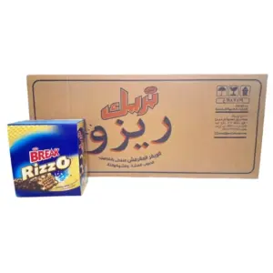 صورة لشوكولاتة بريك ريزو (Break Rizzo) الحجم الكبير 28 غرام، تظهر العبوة الزرقاء والذهبية الجذابة بجانب كرتون التوزيع الذي يوضح تفاصيل حبيبات الأرز المنفوخ والويفر. 