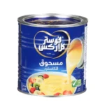 صورة لعلبة مسحوق كاسترد فوستر كلاركس (Foster Clark's) الزرقاء الشهيرة بوزن 450 غرام، بجانب طبق كاسترد أصفر كريمي مزين بقطع الفواكه الطازجة.