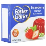 صورة لعلبة جيلي فوستر كلاركس (Foster Clark's) الزرقاء بنكهة الفراولة بوزن 85 غرام، تظهر قوام الجيلي المتماسك واللون الأحمر الجذاب للفراولة.